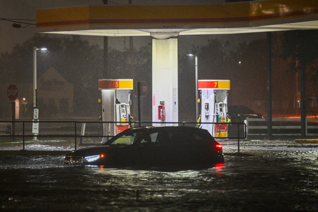 A vehicle is stranded on a water-flooded street after Hurricane Milton made landfall in Brandon, Florida.
