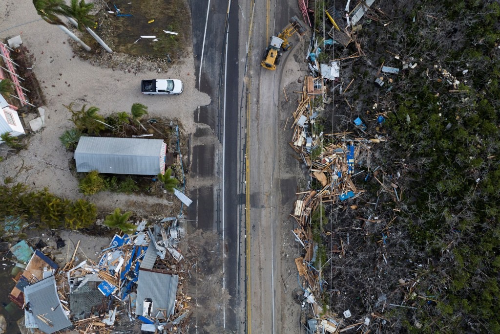 A drone view shows a bulldozer removing debris from a road after Hurricane Milton made landfall in Matlacha, Florida.
