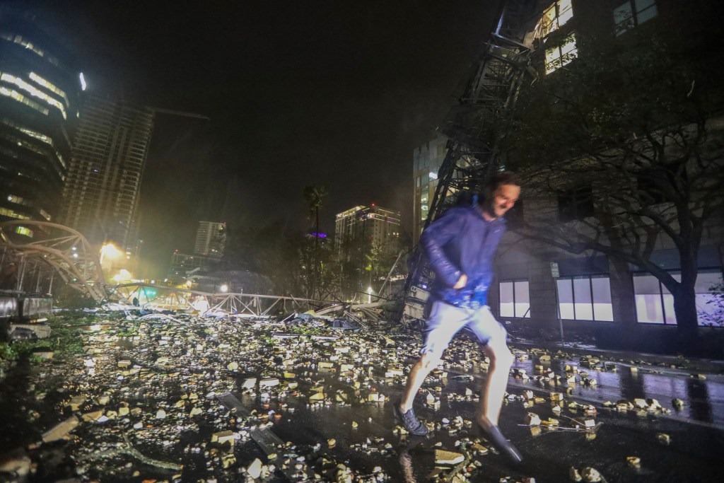 Joe Lindquist, 32, of St. Petersburg, walks over bricks near a fallen crane along 1st Avenue South near the Tampa Bay Times offices in St. Petersburg, Florida.
